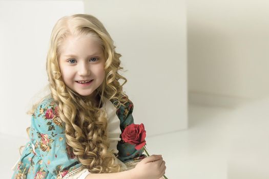 Beautiful little girl with a flower in her hands. The concept of beauty and fashion, happy childhood.