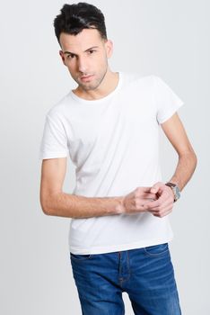 Portrait of a smart serious young man standing against white background