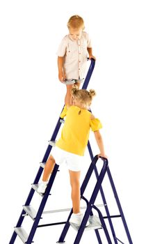 Friendly kids, brother and sister, boy and girl, play together on the stairs in an indoor obstacle quest. The concept of active play in the home room, quarantine, self-isolation. Isolated over white background.
