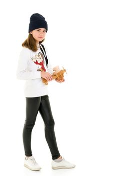 Happy little girl is playing with a wooden plane in the studio on a white background. The concept of emotions and children's games. Isolated.