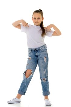 A nice little girl in a clean white T-shirt is pointing at something. The concept can be used to advertise goods and services whose logo can be printed on the surface of a shirt. Isolated on white background.