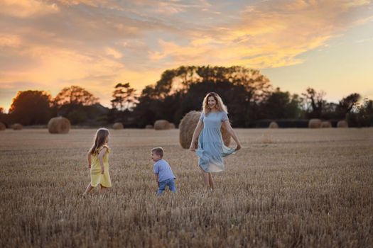 Mother and kids near bales of wheat Countryside
