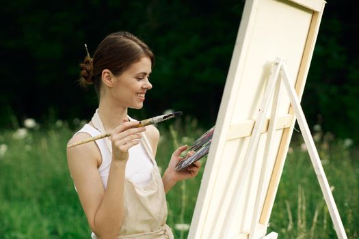 cheerful woman artist painting a picture outdoors creative art. High quality photo