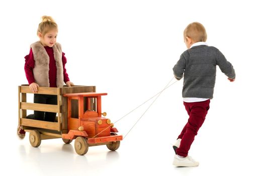 Brother and sister are playing with a toy car. The concept of happy childhood, people, harmonious development of the child in the family. Isolated on white background.