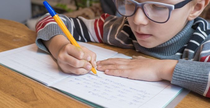 Focused first grader learning to write and doing homework.