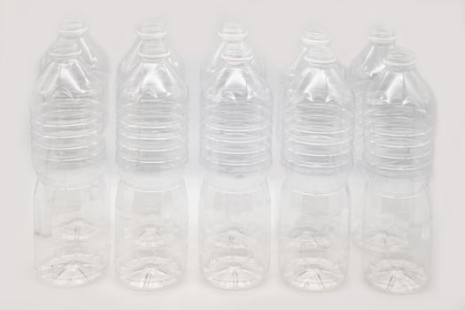 Row of plastic mineral water bottles isolated on a white background.
