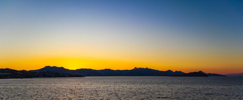 Beautiful bright colorful sunset on the Mediterranean Sea with islands, mountains and boats