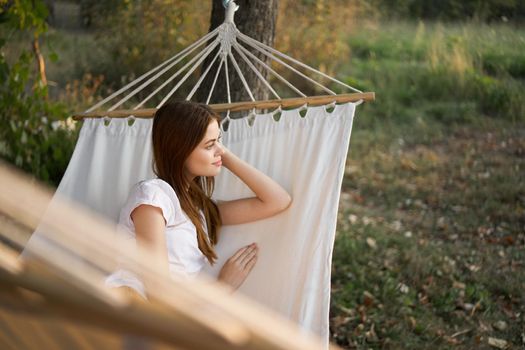 woman relaxing in nature in a hammock garden fresh air. High quality photo