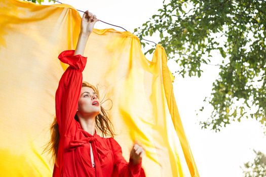 woman in red dress outdoors yellow bedspread. High quality photo