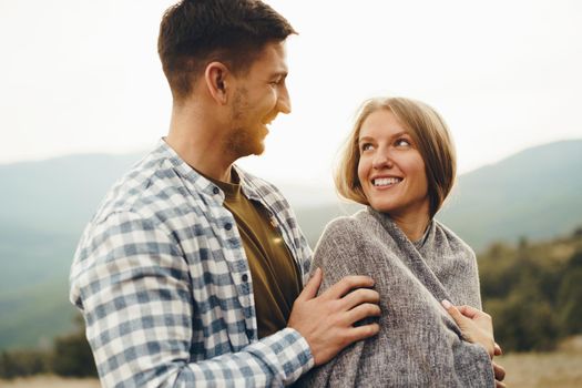 Happy loving couple hiking and hugging in mountains, close up