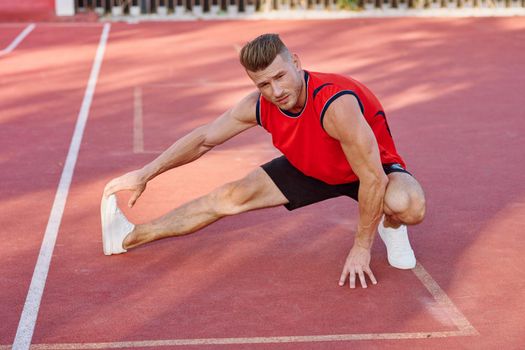 athletic man doing exercises outdoors sports field exercise. High quality photo