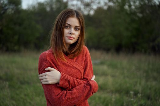 woman in a red sweater outdoors in the field nature rest. High quality photo