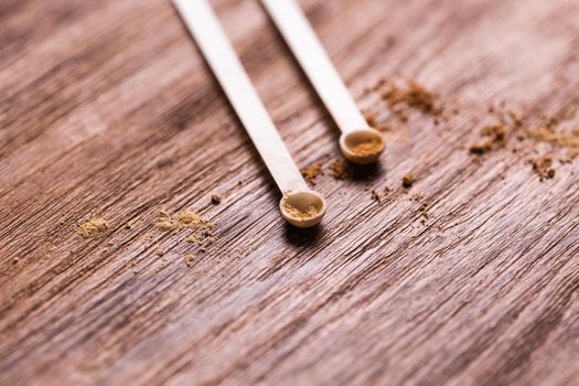 Mineral powder of different colors with spoon dispenser for make-up on wooden background.