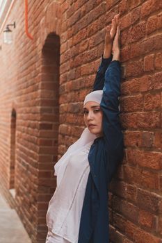 Portrait of female model in fashionable hijab style posing on urban background. Stylish Muslim woman hijab fashion lifestyle portraiture concept