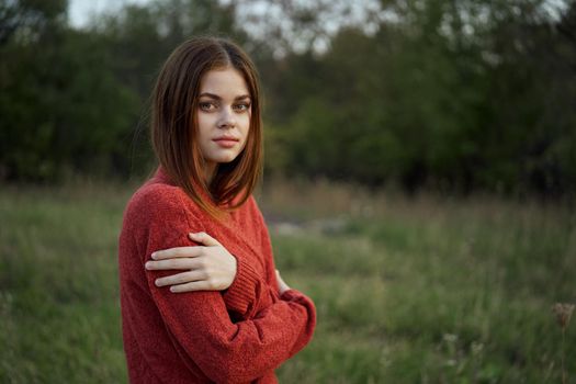 woman in a red sweater outdoors in the field nature rest. High quality photo