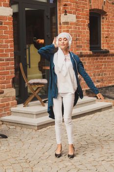 Portrait of young arabian muslim woman listening music with headphone and dancing. Feminism, woman independence and leisure concept