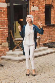 Portrait of young arabian muslim woman listening music with headphone and dancing. Feminism, woman independence and leisure concept