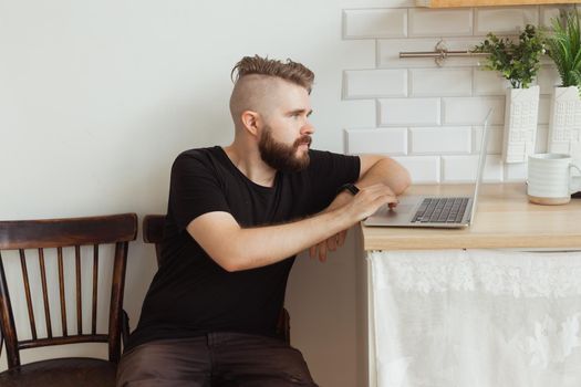 Smiling man working with laptop at home. Technology, home and lockdown concept.