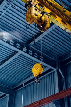 Industrial crane hook in a modern factory building close up