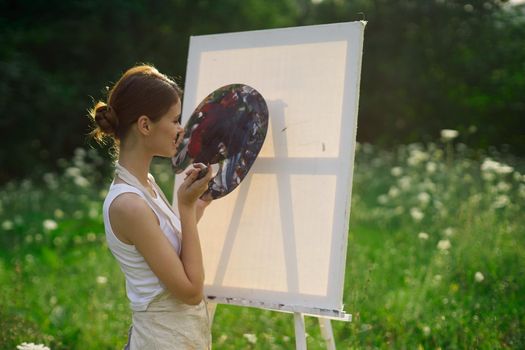 woman artist outdoors paint palette painting landscape. High quality photo