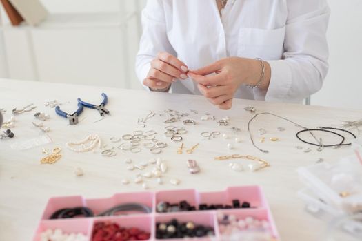 Professional jewelry designer making handmade jewelry in studio workshop. Fashion, creativity and handmade concept.