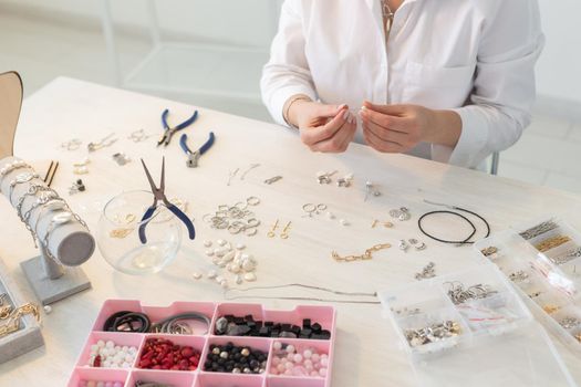 Professional jewelry designer making handmade jewelry in studio workshop. Fashion, creativity and handmade concept.