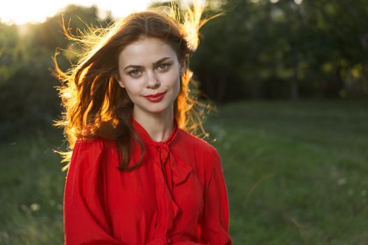 cheerful woman in a red dress in a field outdoors fresh air. High quality photo