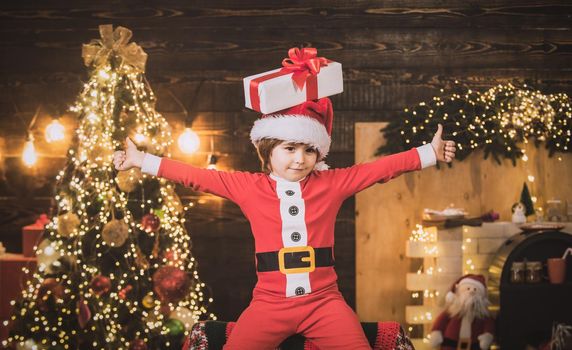 Funny little boy child with present or gift box on head. New year kids, Fun christmas concept. Winter child emotion