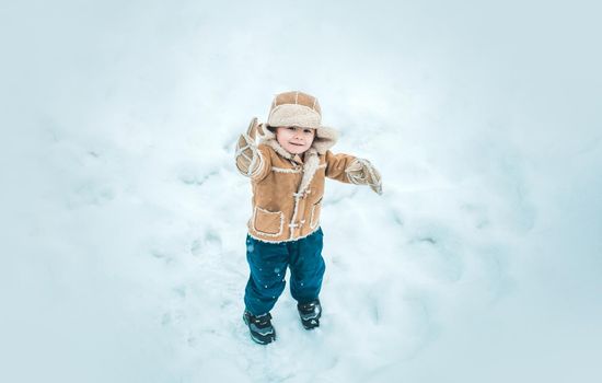 Winter child happy in snow outdoor. Cute boy in winter clothes. Theme Christmas holidays and New Year