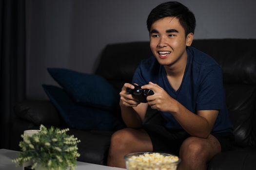 happy young man playing video games at night