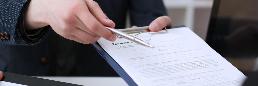 Male hand holding silver pen ready to make note in opened notebook sheet. Businessman in suit at workspace make thoughts records at personal organizer, white collar conference, signature concept