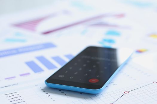 Smartphone calculator and financial statistics ondisplay tablet at office table closeup. Internal Revenue Service inspector sum check, irs investigation, earnings, savings, loan and credit concept