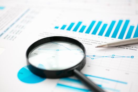 Financial statistics documents on lens and pen office table closeup. Internal Revenue Service inspector sum check, irs investigation, exchange market, earnings, savings, loan and credit concept