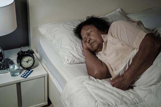 senior woman sleeping in a bed at night