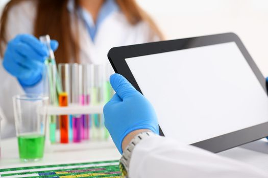 A male doctor in a chemical laboratory holds a tablet in his hand with a clean display, you can insert a picture or an image you want to write for an advertising company