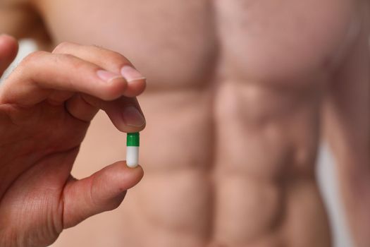 Athlete bodybuilder takes dope in the form of tablets form of pharma rapid progress in muscle development