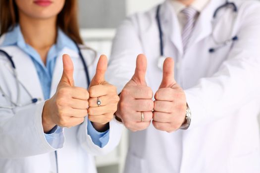 Group of doctor arms show OK or confirm sign with thumb up closeup. High level therapy, great heal participation, healthy lifestyle, satisfied patient, therapeutist, best consultation, physical