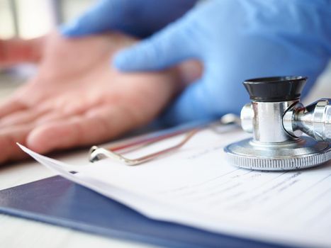 The doctor examines the healing wound of the patient on the hand palm scarring healing