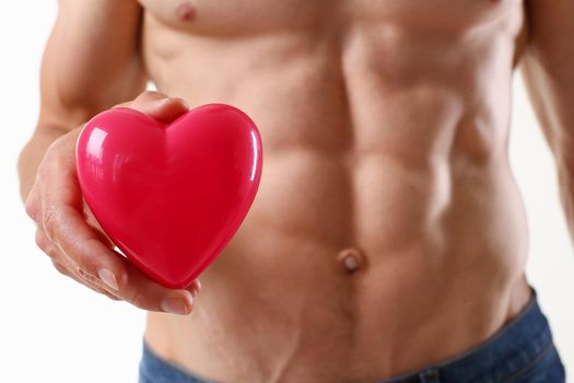 Athletic man holds a heart in his hand