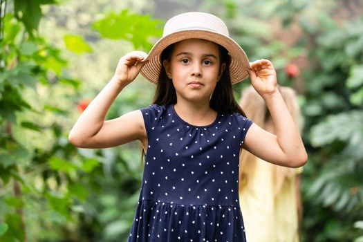 two little girls with butterflies in a greenhouse