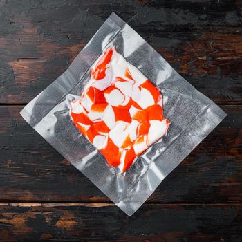 Surimi vacuum pack set, on dark wooden background, top view flat lay