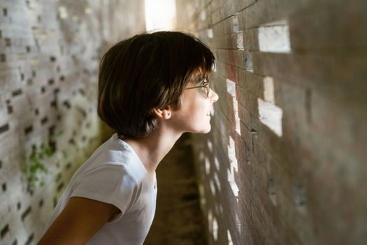 Child looking through the bricks inside the restoration of the Nazari Wall of the Albaicin in Granada, made by the architect Antonio Jimenez Torrecillas