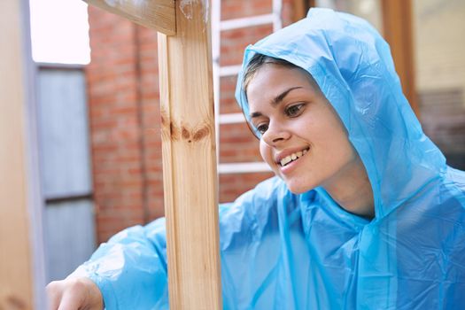 cheerful woman house painter repairing wooden structure. High quality photo