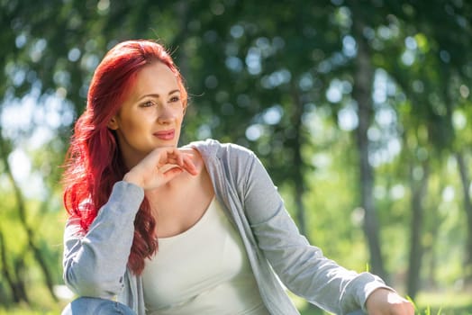 Portrait of a young attractive woman in the park. Smiling and happy