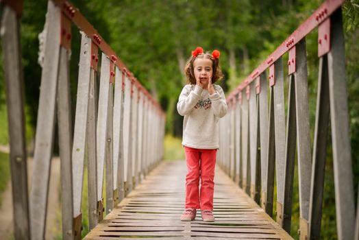Cute little girl with four years old having fun in a rural bridge
