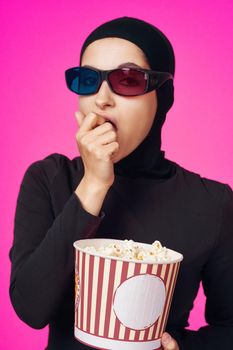 pretty woman in 3D glasses popcorn entertainment movies purple background. High quality photo