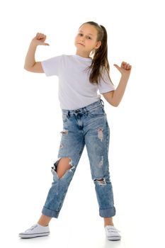 A nice little girl in a clean white T-shirt is pointing at something. The concept can be used to advertise goods and services whose logo can be printed on the surface of a shirt. Isolated on white background.