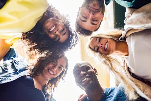 Group of young people together outdoors in urban background. Men and women looking down