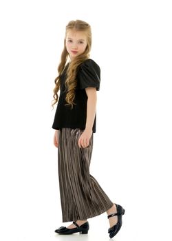 Cute little girl in trousers. The concept of style and fashion. Isolated on a white background.