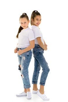 Two cute little girls in full growth, in the studio on a white background. The concept of a happy childhood, Beauty and fashion. Isolated.